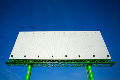 Low angle view of windmill against clear blue sky