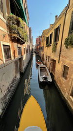 A yellow motorboat in a canal in venice.