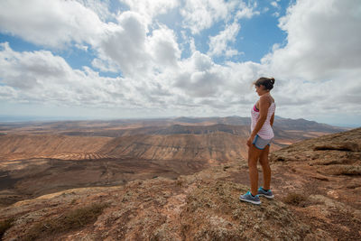 Full length of man standing on mountain against sky