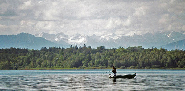 Man surfing in lake against sky