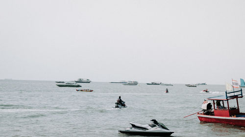 People on sea against clear sky