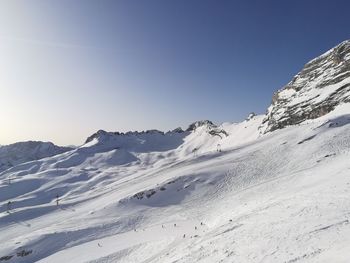 Scenic view of snowcapped mountains against clear blue sky