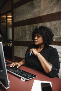 Businesswoman using computer sitting at desk in law office