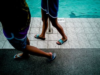 Low section of people standing by swimming pool