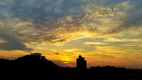 Silhouette city against sky during sunset