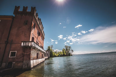 Building by river against sky