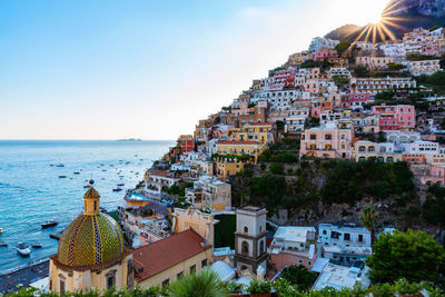 High angle view of townscape by sea against clear sky