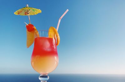 Close-up of drink in glass against blue sky