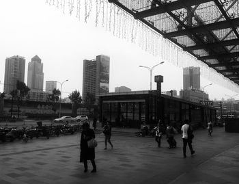 People walking on street against buildings in city