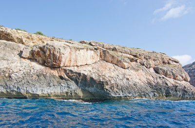 Scenic view of sea and cliff against clear sky