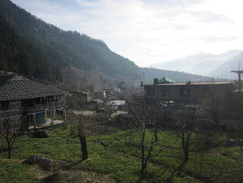 Houses by mountains against sky