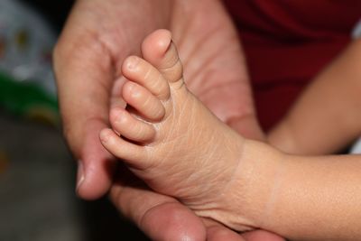 Close-up of mother holding baby foot