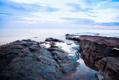 Rock formations by sea against sky