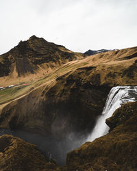 Scenic view of waterfall against sky