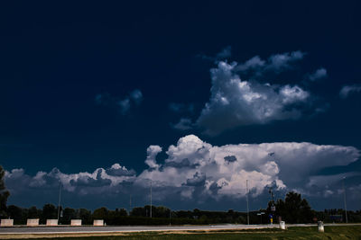 Panoramic view of land and trees on field against sky