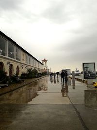 People on wet road in city during rainy season