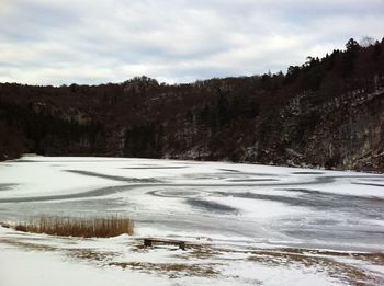Frozen lake against sky during winter