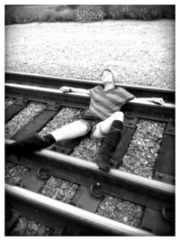 High angle view of woman sitting on railroad track