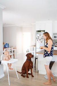 Side view of young woman with dog sitting at home