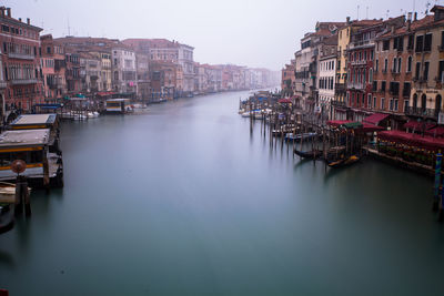 Boats in canal along built structures