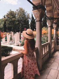 Rear view of woman standing by railing