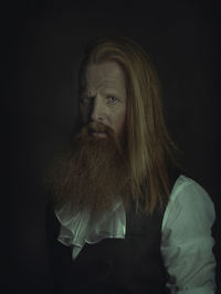 Portrait of man against black background