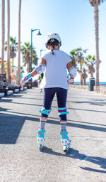 Rear view of girl inline skating on road