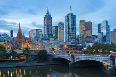 Bridge over river against buildings in city