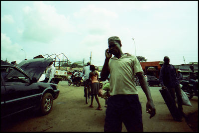 People on street in city against sky