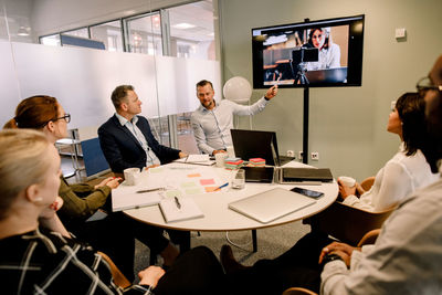 Business professionals having video conference meeting in board room