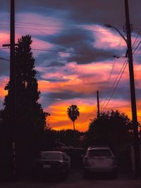 Cars on road against sky during sunset