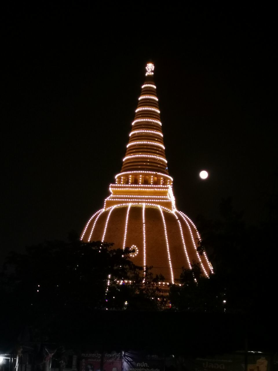 LOW ANGLE VIEW OF ILLUMINATED CHRISTMAS LIGHTS AGAINST BUILDING