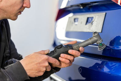 Midsection of man repairing car