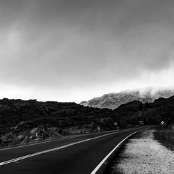 Empty road along landscape against sky