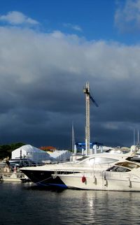 Sailboats moored at harbor