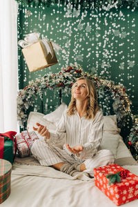 Young happy woman rejoices with christmas gifts.