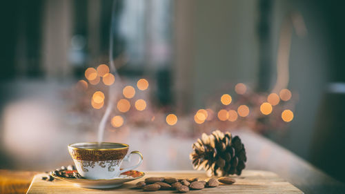 Coffee cup and pine cone on table