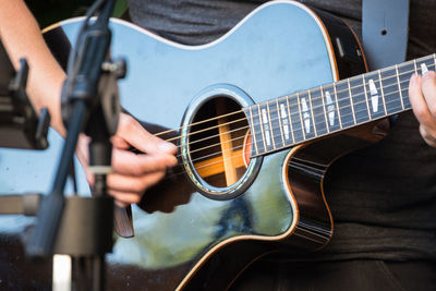 Midsection of man playing guitar