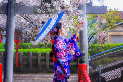 Midsection of woman holding umbrella