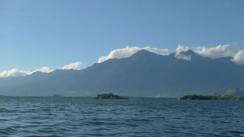 Scenic view of sea and mountains against sky