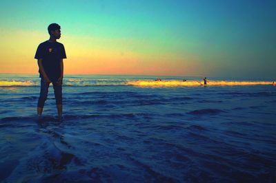 Silhouette of people on beach at sunset