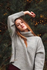 Portrait of a young woman sitting on tree