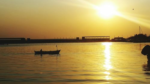 Silhouette of boat in sea at sunset