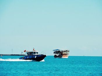 Ship sailing on sea against clear sky