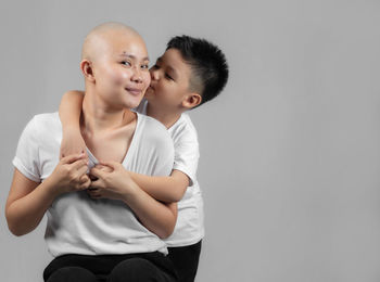 Father and son looking away against white background