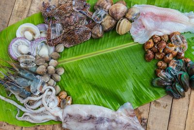 High angle view of various seafood in banana leaf on table