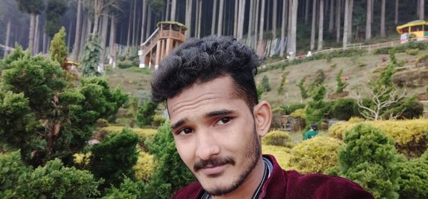 Portrait of young man against plants