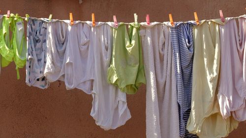 Clothes drying on clothesline against white wall