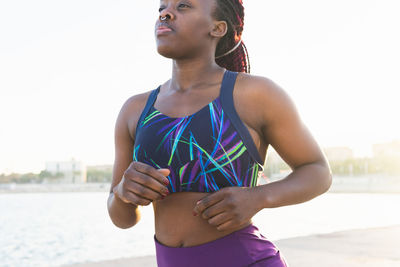 Determined fit black woman athlete in sportswear running at the sea shore on a sunny day