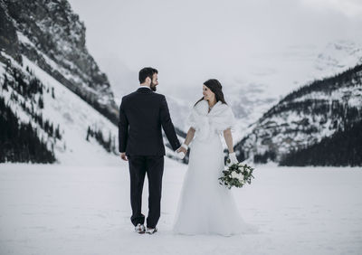 Bride and groom wedding on ice in winter lake louise, alberta, canada